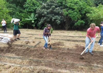Três alunos do curso de Engenharia Agronômica da Facens preparando o solo para a implementação da horta no local.